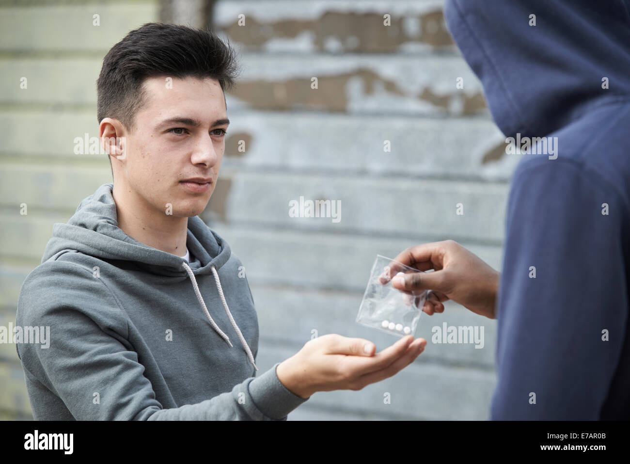 Ragazzo adolescente Acquisto di Farmaci sulla strada dal concessionario Foto Stock