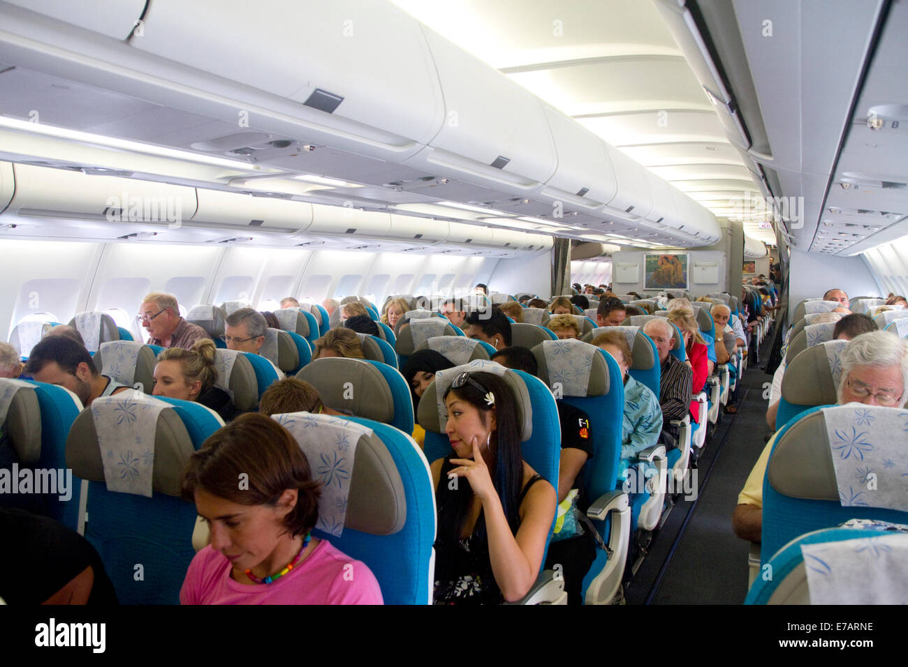 I passeggeri a bordo di un Airbus 340 seduto nella cabina economy. Foto Stock