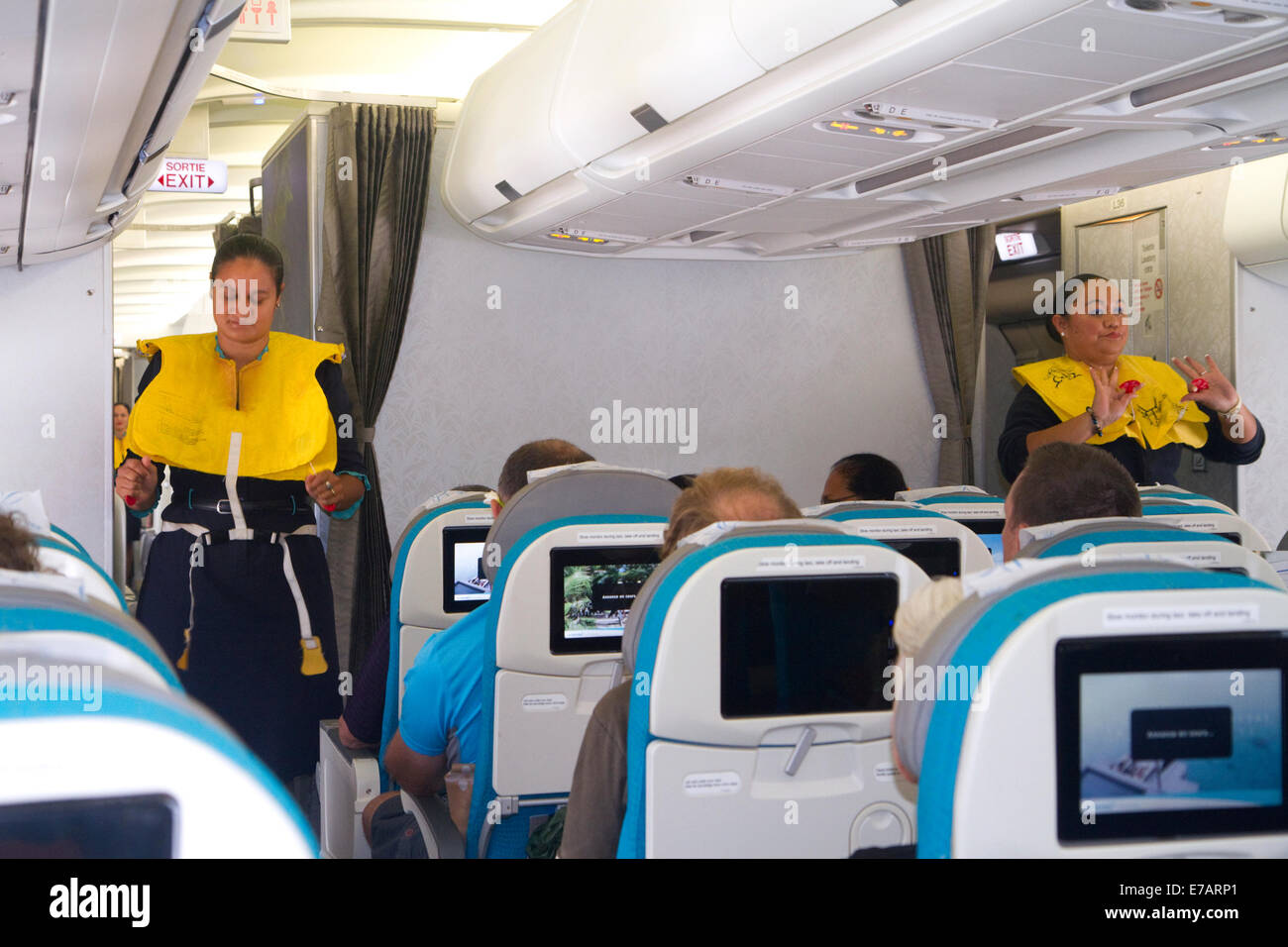 I passeggeri seduti in un Airbus 340 con assistente di volo dando istruzioni di sicurezza all'Aeroporto di Auckland Auckland New Zealan Foto Stock