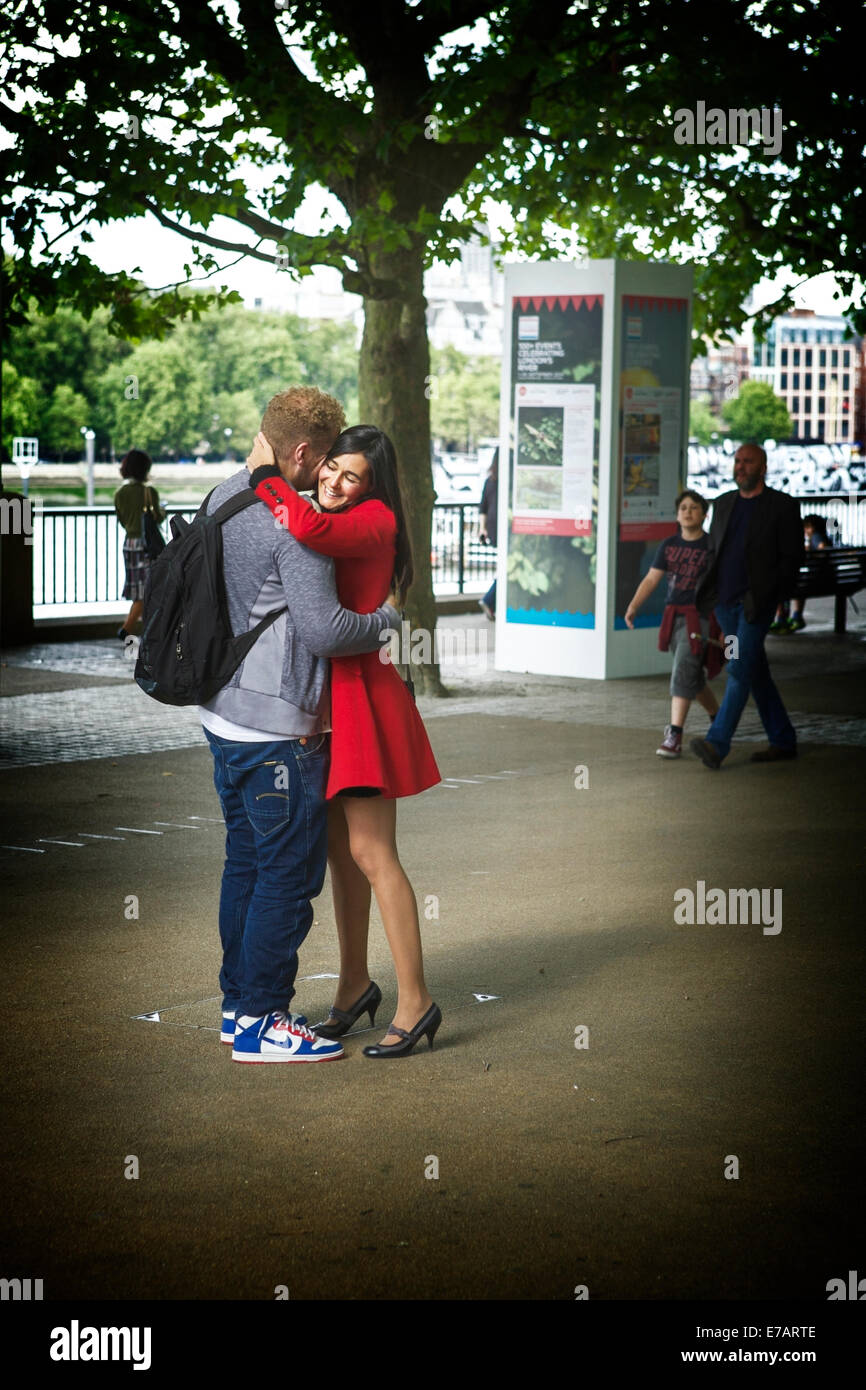 Coppia giovane abbracciando, nella Southbank Londra, Inghilterra, Regno Unito. Londra Southbank. Matura avvolgente. Foto Stock