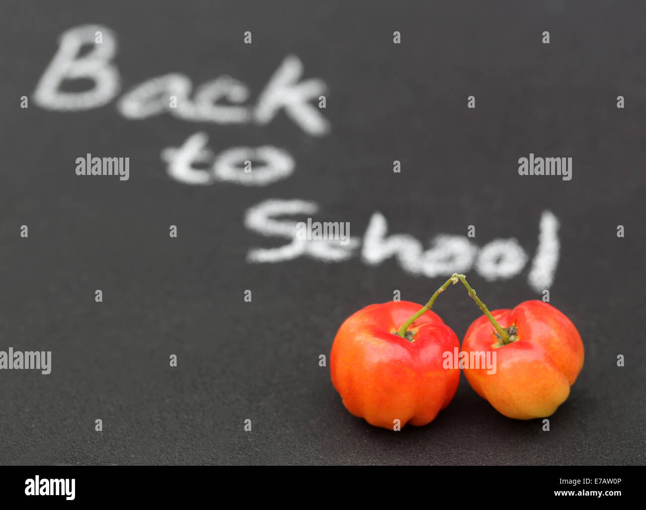 Si torna a scuola scritto in un bordo nero con ciliegia matura Foto Stock