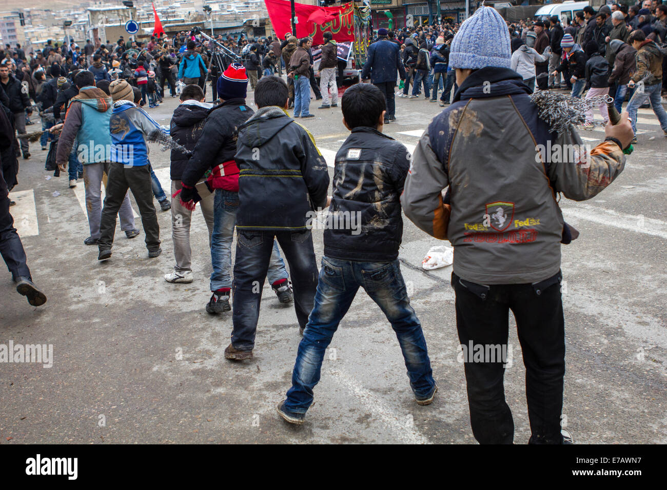 Mussulmano sciita di uomini e ragazzi, canti e auto-flagellating durante il giorno di Ashura, sulle strade di Bijar, Iran. Foto Stock