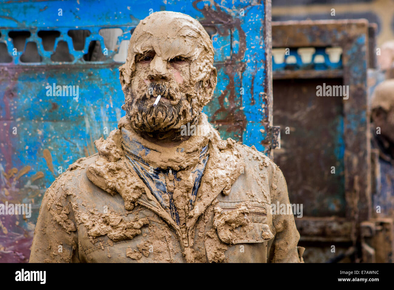 Mussulmano sciita uomo, completamente ricoperte di fango, fumare una sigaretta, sul giorno di Ashura, in Bijar, Iran. Foto Stock