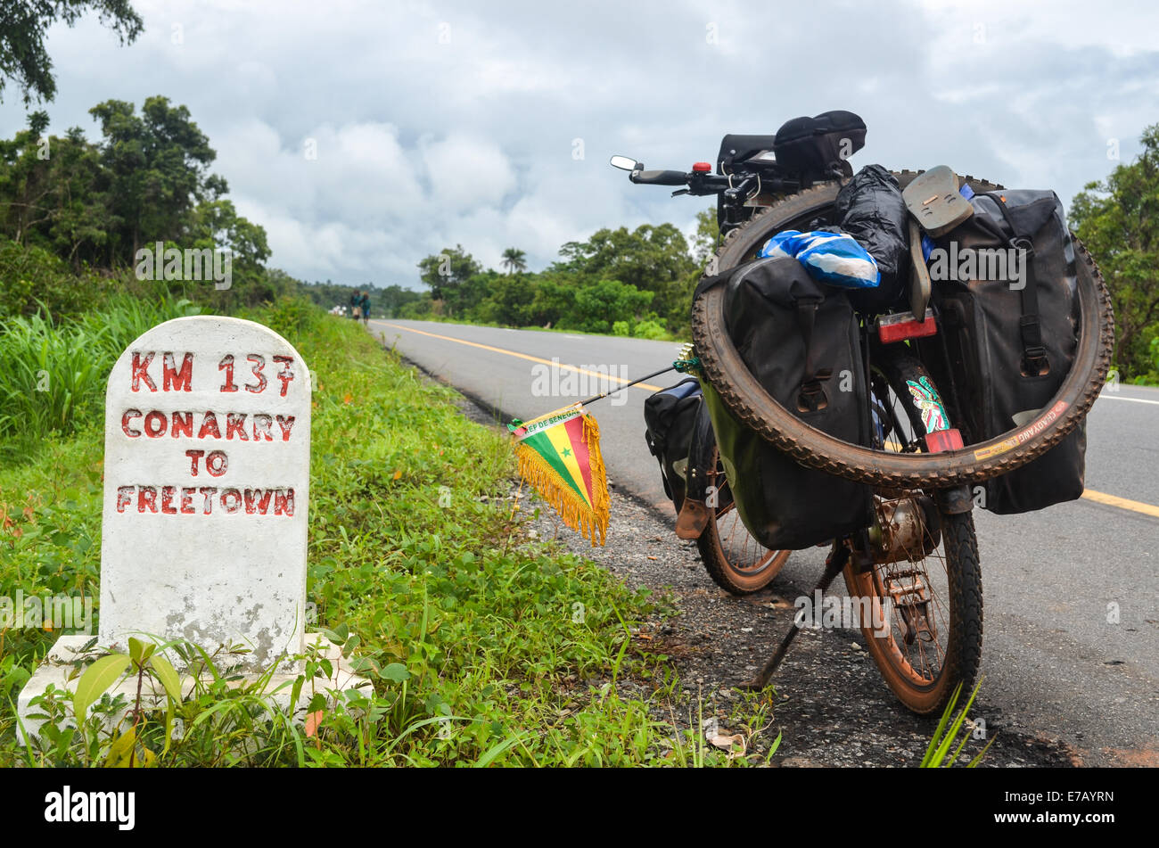 La lettura della fase cardine chilometri da Conakry a Freetown sul finanziato dall'UE di nuova costruzione strada in Sierra Leone Foto Stock