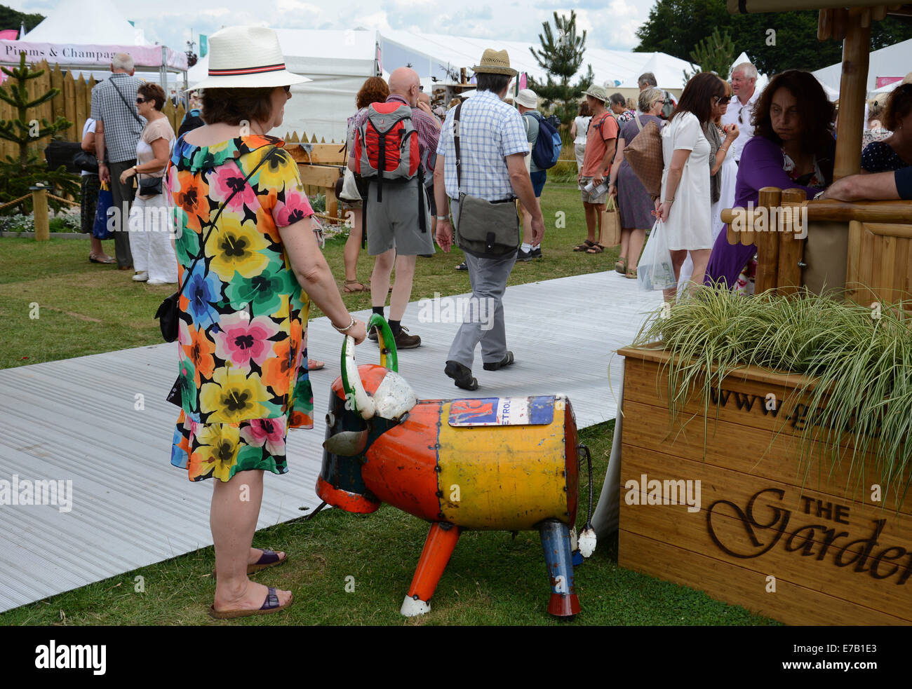 Tatton Park, flower show Signora con la mano sulla scultura di mucca, Inghilterra. Foto Stock