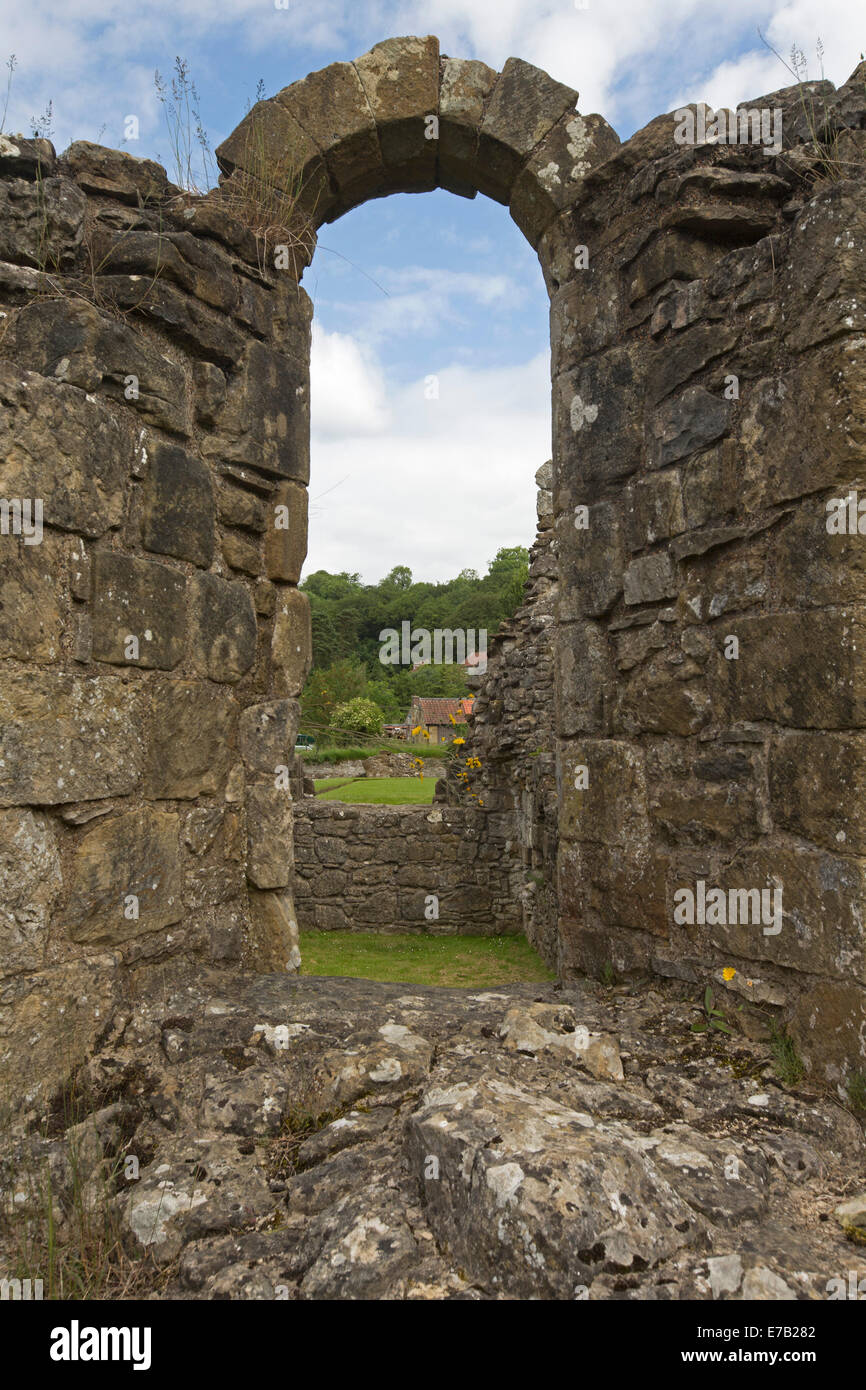 Visualizzazione attraverso l'arcata in pietra a pittoresche rovine della storica del XII secolo Rievaulx Abbey, monastero cistercense in Yorkshire, Inghilterra Foto Stock