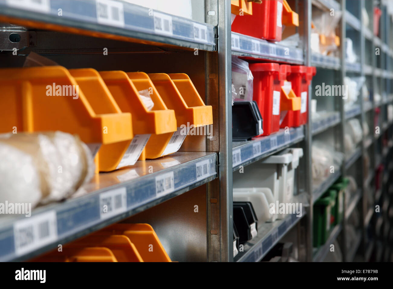 Contenitori di archiviazione e rack in un magazzino shot con il fuoco selettivo Foto Stock