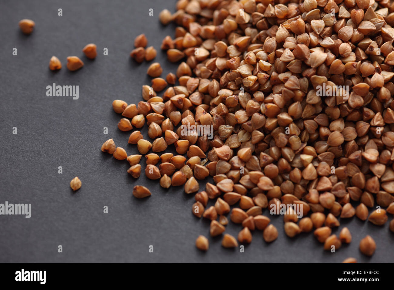 Il grano saraceno su un nero lo sfondo della carta. Close-up. Foto Stock