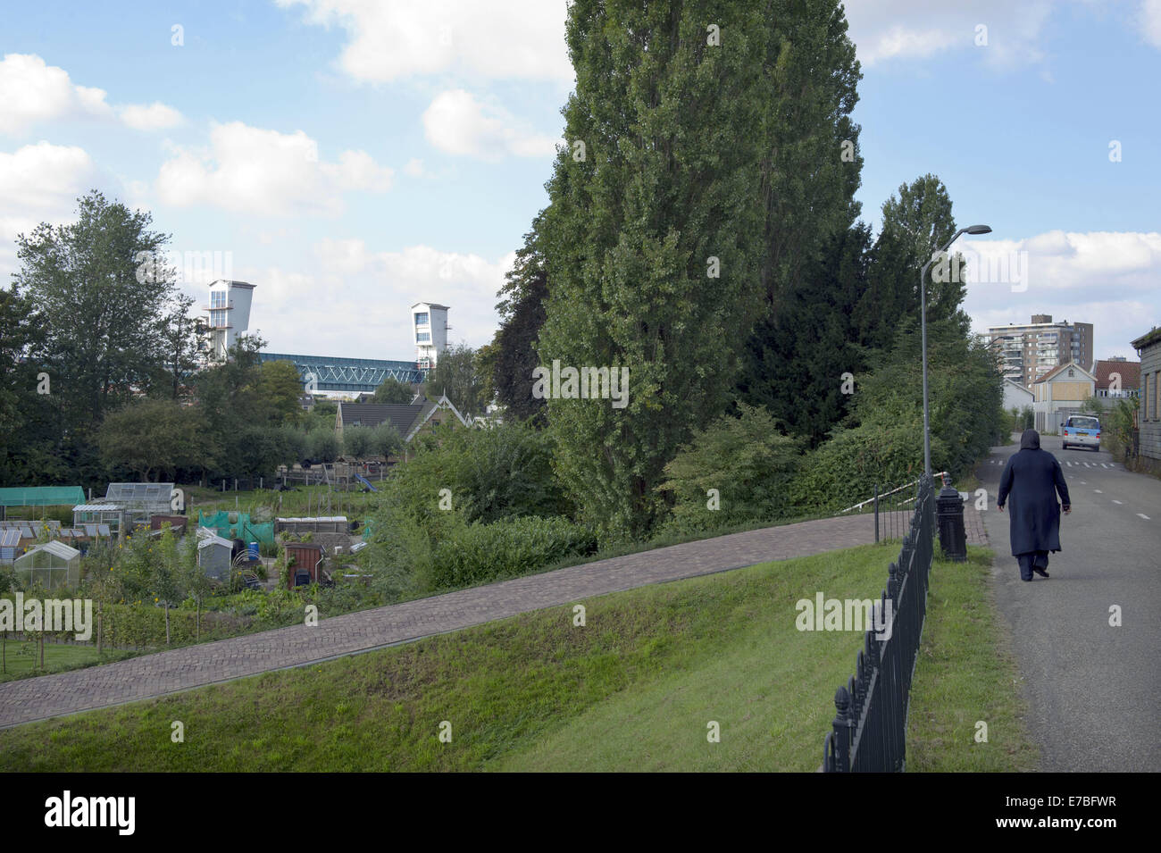 Sett. 10, 2014 - Rotterdam South Holland, Paesi Bassi Olanda - l'olandese Ijssel dam. Una donna cammina su una diga. Il Hollandse IJssel (Olandese IJssel) collega Rotterdam con il Mare del Nord. In caso di alluvione, il fiume di acqua potrebbe non essere in grado di scorrere lontano perché la risalita di acqua di mare ad arrestarlo. Il fiume avrebbe pertanto burst facilmente le sue rive. Vi sono due motivi principali per la ricerca di una soluzione per il pericolo di inondazione: in primo luogo, il Hollandse Issel fluisce attraverso il più basso giacente zona dei Paesi Bassi. In secondo luogo, questa è una delle aree più densamente popolate del Paesi Bassi. ..Inizialmente, BU Foto Stock