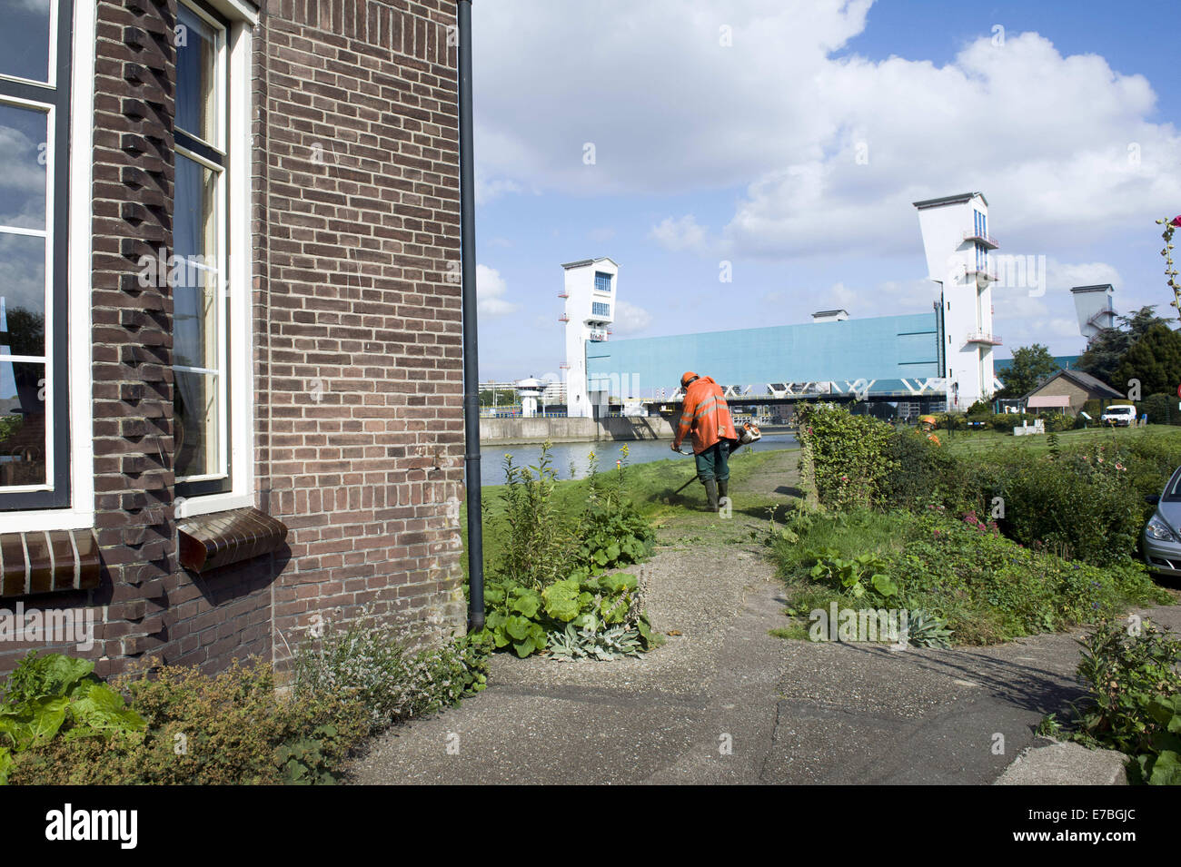 Rotterdam South Holland, Paesi Bassi, Olanda. Decimo Sep, 2014. Un uomo è Falciare il prato da una diga e nella parte anteriore del Dutch Ijjssel dam. A sinistra una piccola diga house. Il Hollandse IJssel (Olandese IJssel) collega Rotterdam con il Mare del Nord. In caso di alluvione, il fiume di acqua potrebbe non essere in grado di scorrere lontano perché la risalita di acqua di mare ad arrestarlo. Il fiume avrebbe pertanto burst facilmente le sue rive. Vi sono due motivi principali per la ricerca di una soluzione per il pericolo di inondazione: in primo luogo, il Hollandse Issel fluisce attraverso il più basso giacente zona dei Paesi Bassi. In secondo luogo, questo è uno di m Foto Stock
