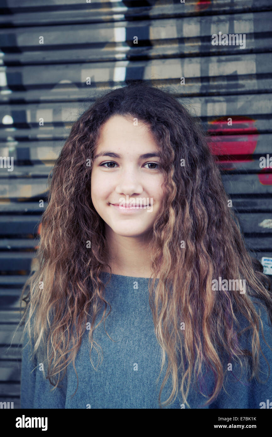 Ragazza adolescente di fronte a una coperta di graffiti vetrina Foto Stock