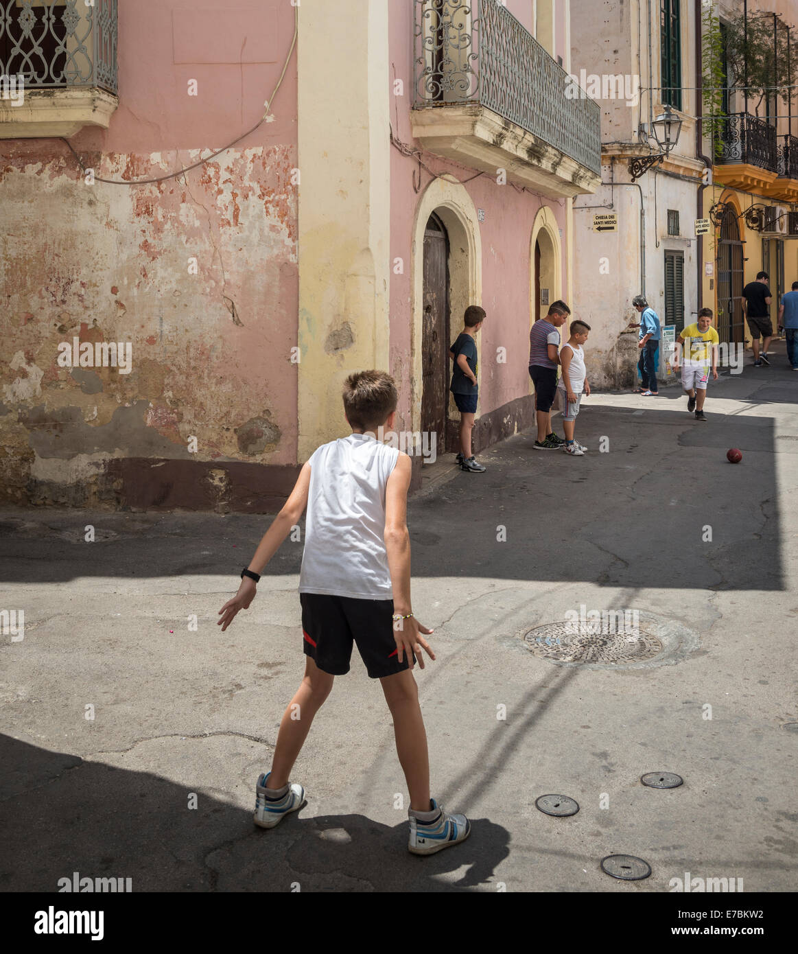 Bambini che giocano a calcio per strada nella vecchia città di pescatori di Gallipoli, Puglia, Italia meridionale. Foto Stock