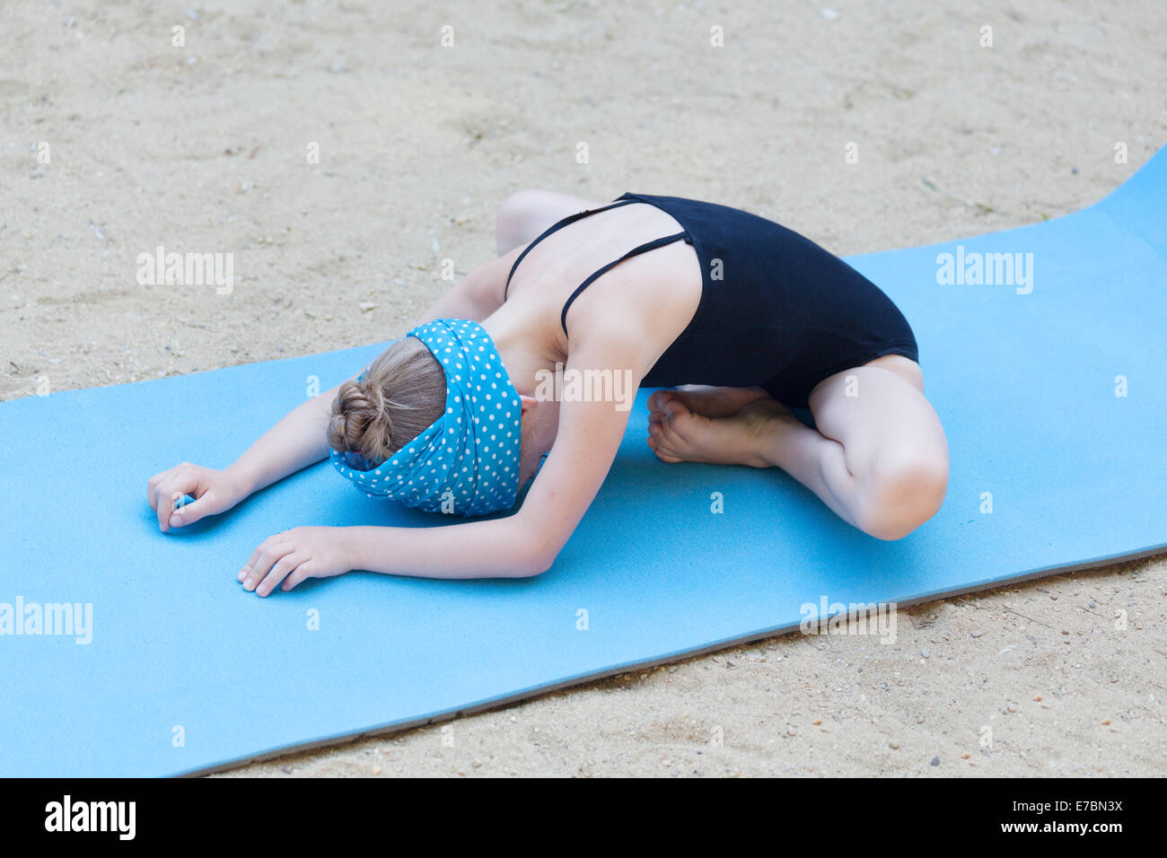 Piccola ragazza di ginnastica stretching all'aperto Foto Stock