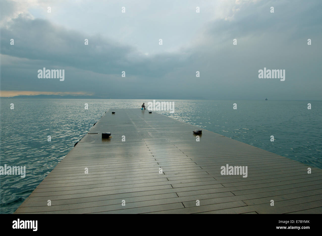 Seduta di pescatori sul molo e la pesca nel Mare del Giappone, Vladivostok, Estremo Oriente, Territorio di Primorye, Federazione russa Foto Stock