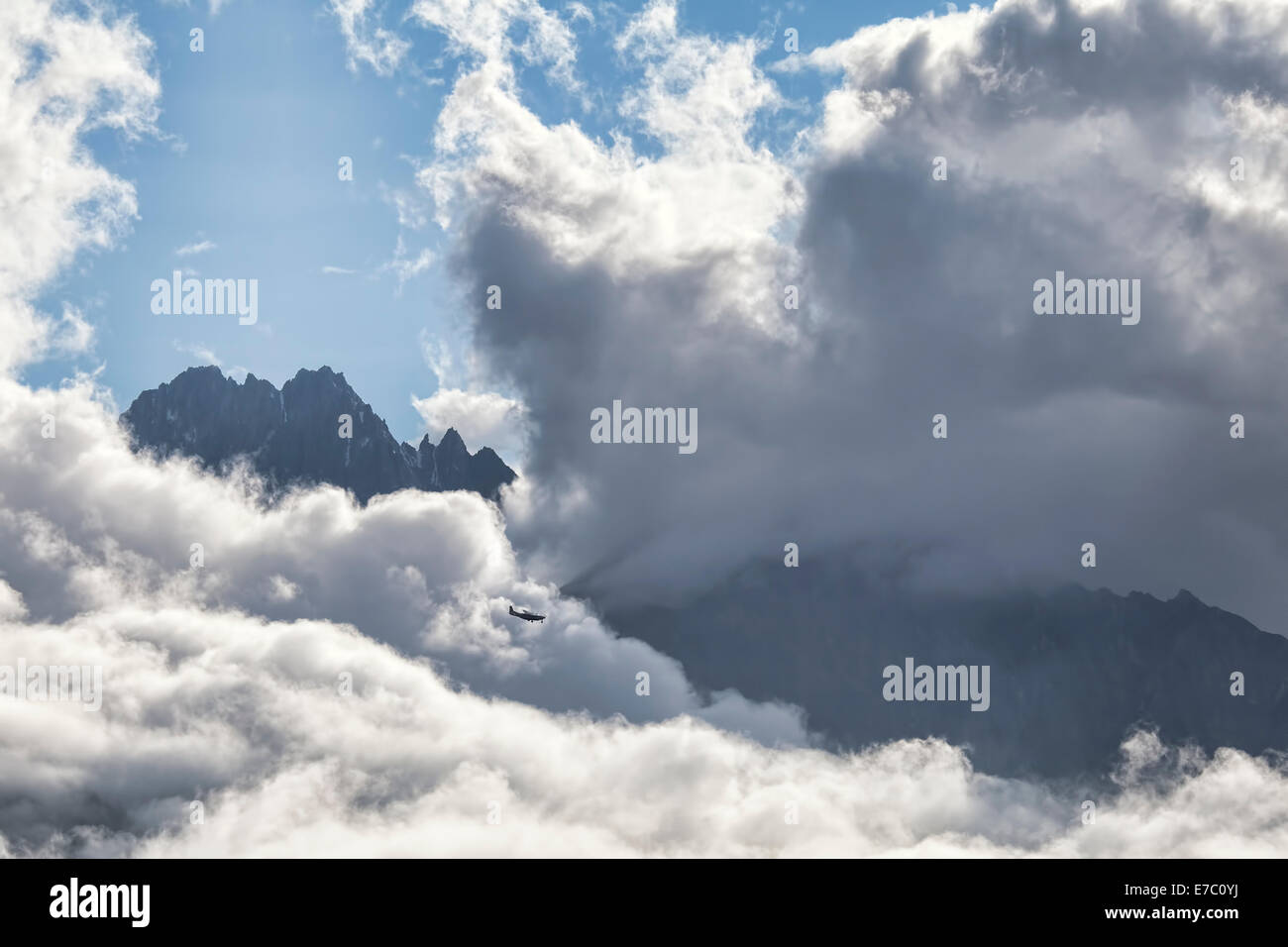 Piccolo aereo attraverso grandi nuvole nelle aspre montagne del sudest dell'Alaska. Foto Stock