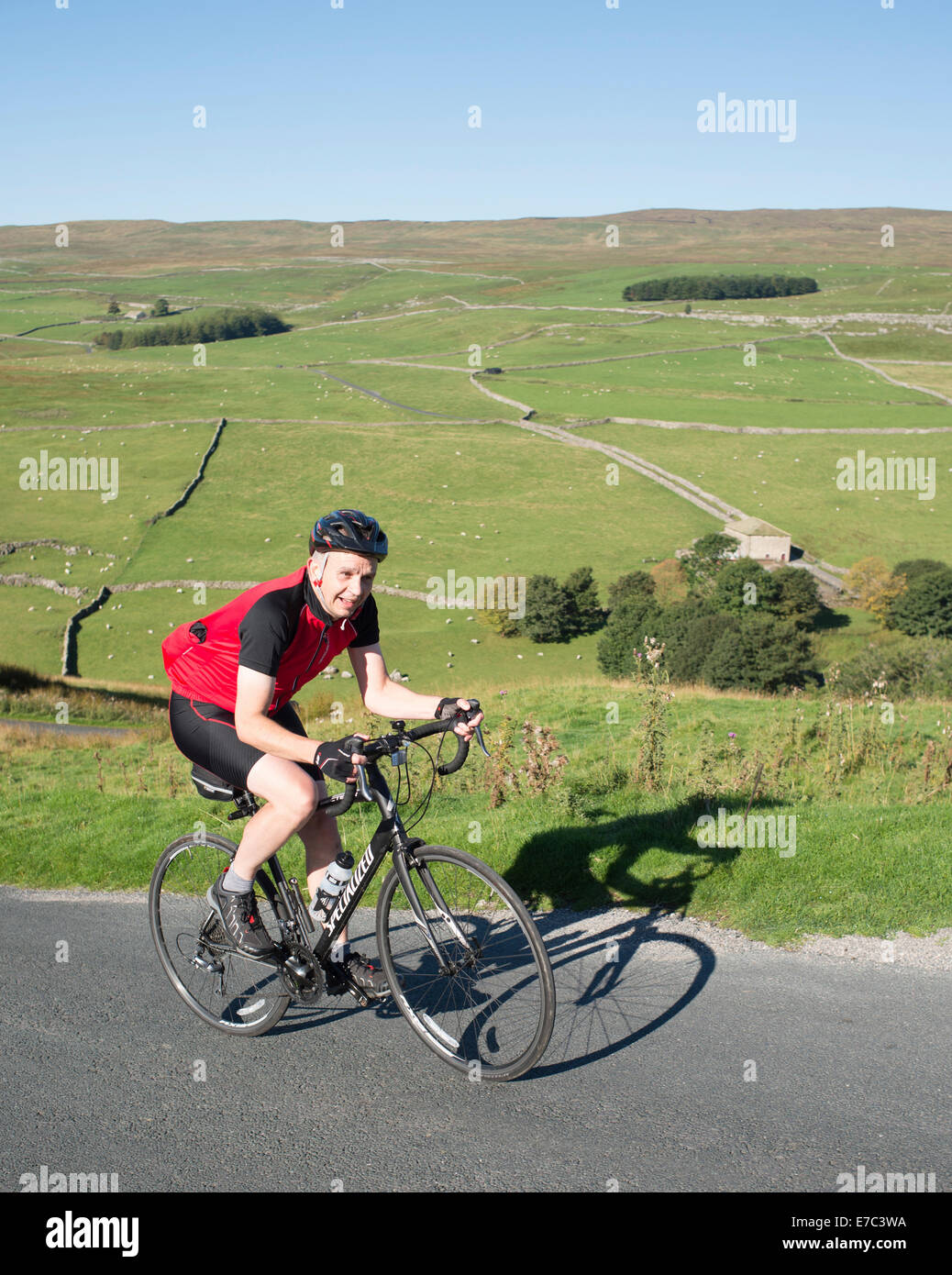 Ciclista salendo un ripido pendio nel Yorkshire Dales National Park Foto Stock