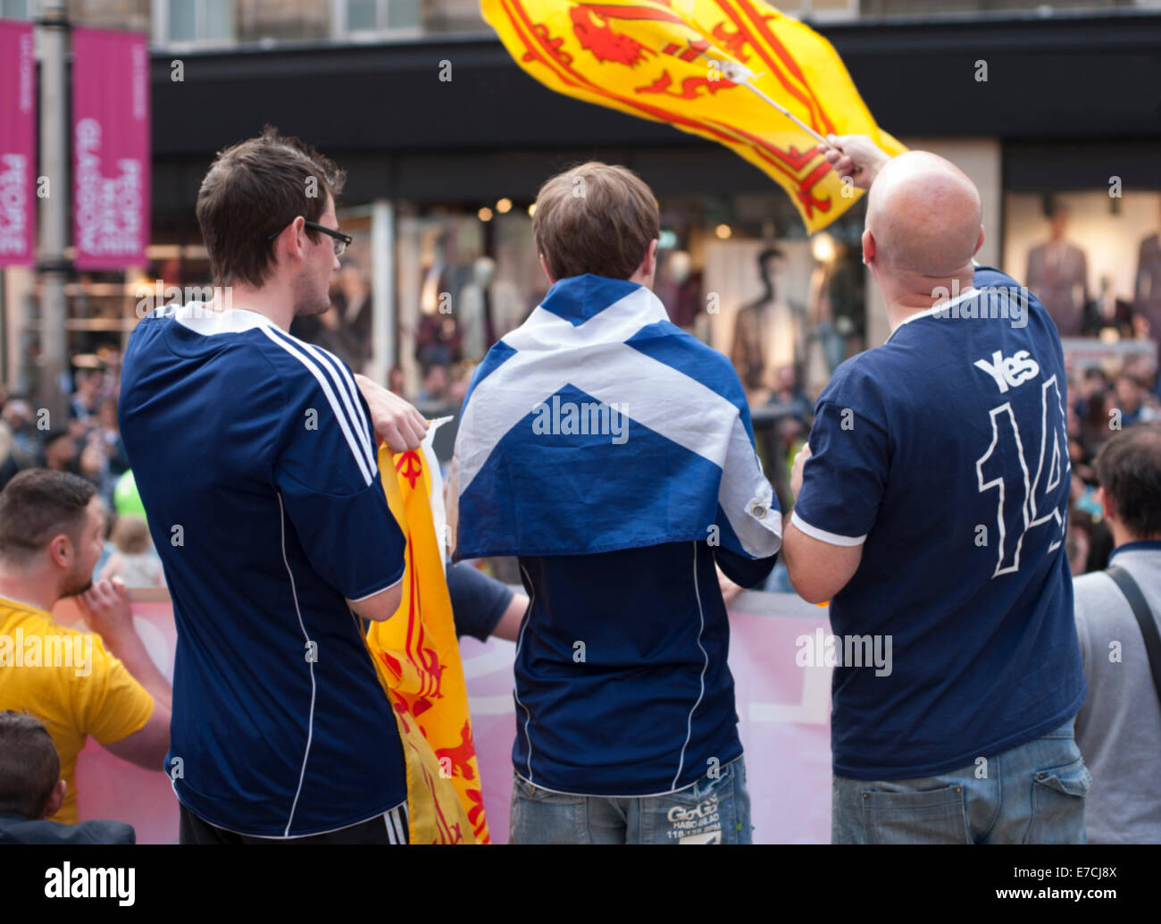 Glasgow, Scotland, Regno Unito. Il 13 settembre 2014. Il retro del maschio tre sì sostenitori holding di bandiere e di indossare la Scozia cime di calcio durante la guida fino a Scottish referendum di indipendenza su Buchanan Street, Glasgow, Scozia sabato 13 settembre 2014 Credit: Iona Pastore/Alamy Live News Foto Stock