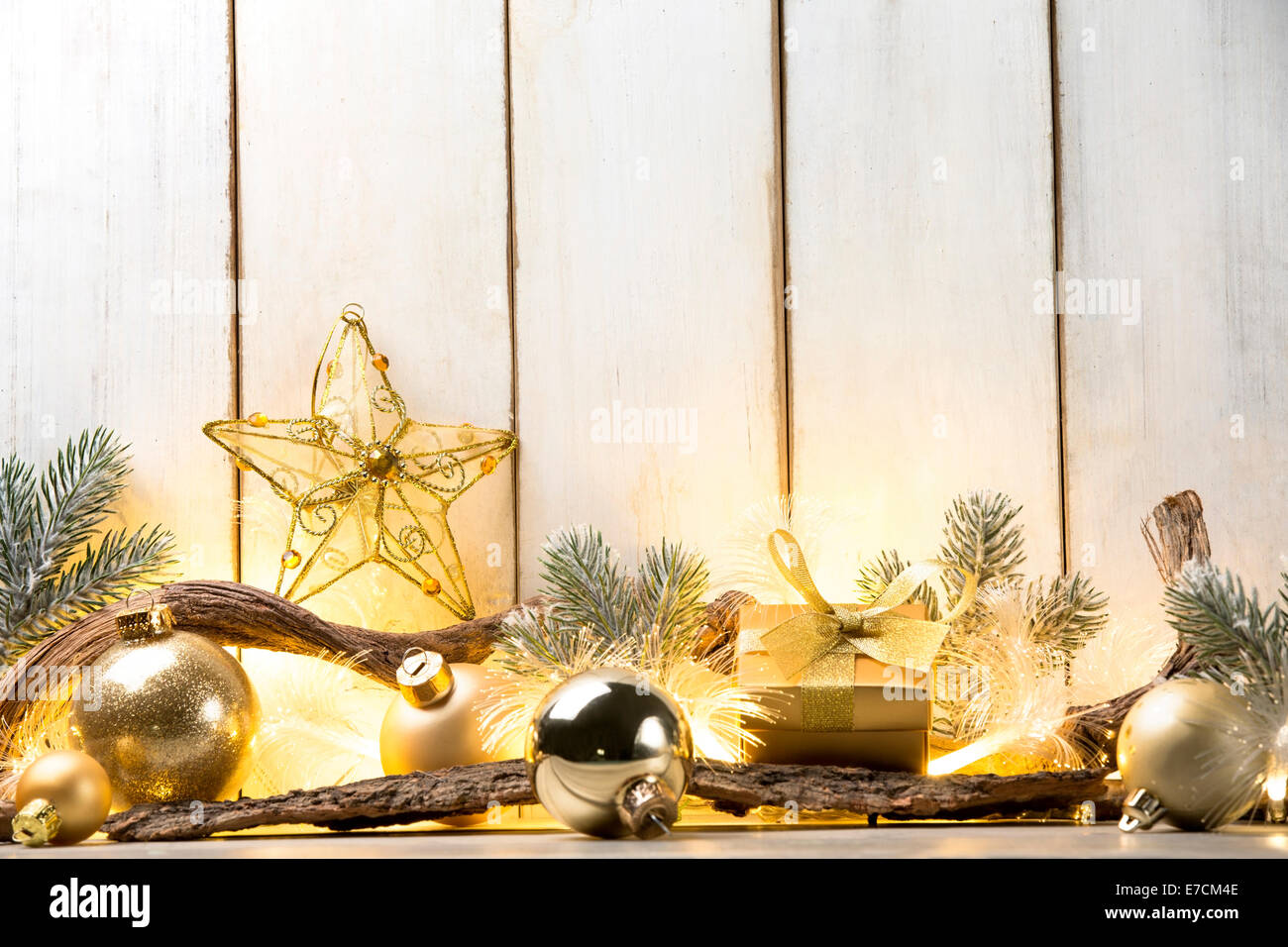 Le palle di Natale,ramo fir,candele accese e dono su asse di legno Foto Stock