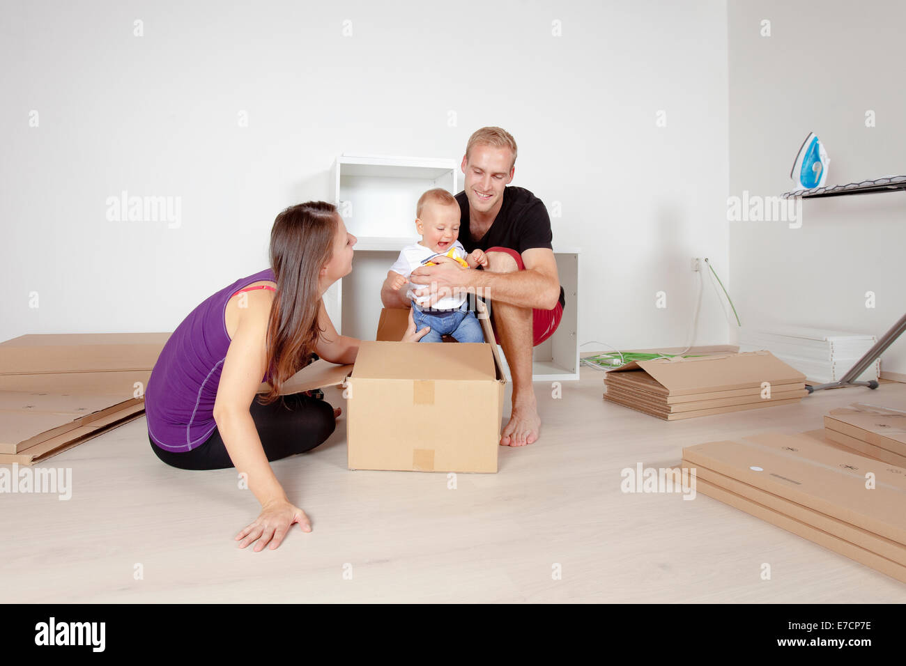 Famiglia giovane con un bambino in movimento in un nuovo appartamento Foto Stock