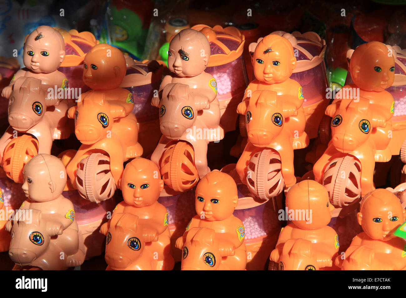 Righe di arancione e rosa di equitazione bambole giocattolo sul display Foto Stock