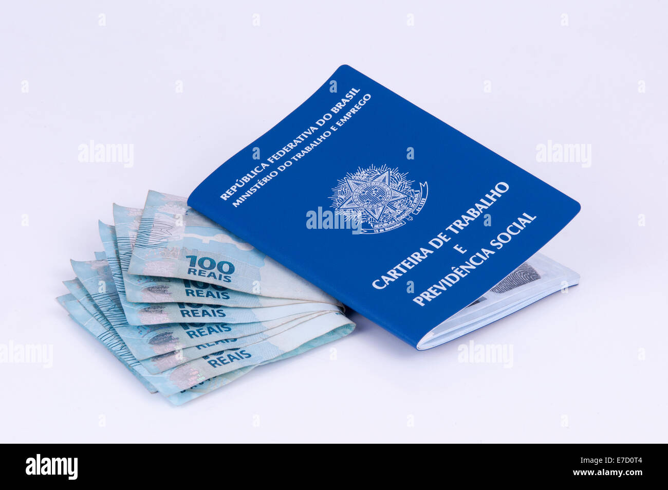 Brasiliano di documento di lavoro e sicurezza sociale documento (Carteira de Trabalho) e valuta brasiliana (reale) su sfondo bianco Foto Stock