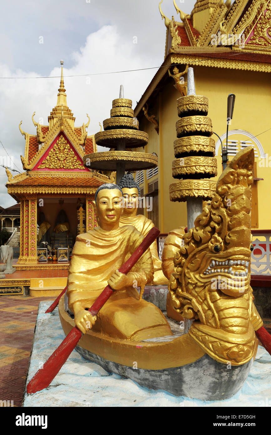 Statua dorata di monaci del canottaggio a sfornare una mari del latte a Wat Dey Dos, Kampong Cham, Cambogia. Il tempio sorge dal Mekong Foto Stock