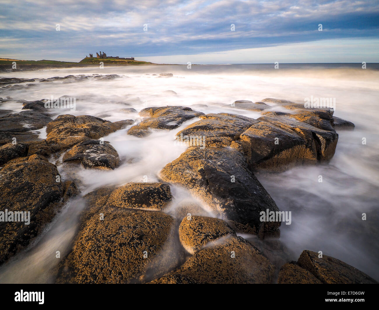 Incredibilmente aspra costa di Isola Santa in Northumberland è protetto da Lindisfarne Castle Foto Stock