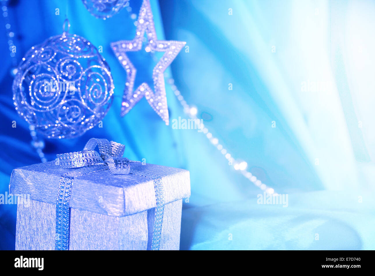 Argento decorazioni di Natale e regalo in tessuto blu sullo sfondo Foto Stock
