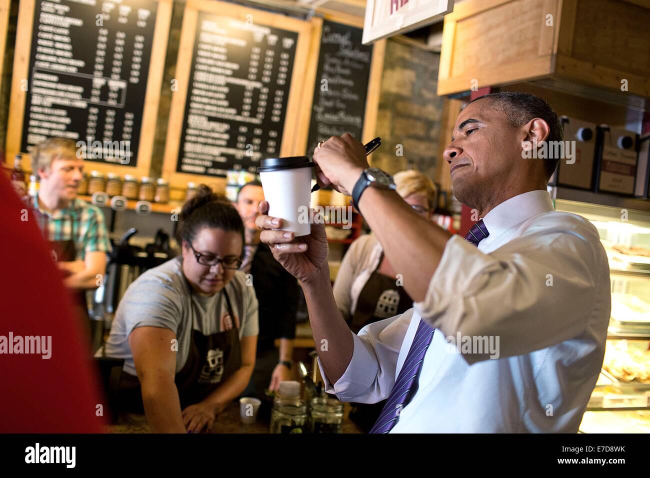 Il Presidente Usa Barack Obama segni una tazza di caffè per un patrono al caffè Parkville Luglio 30, 2014 in Parkville, Missouri. Foto Stock