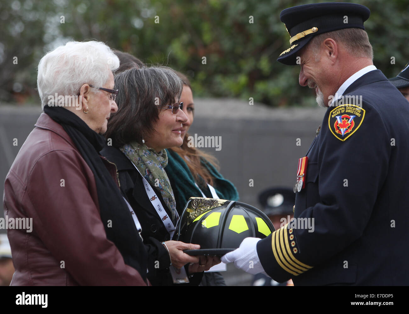 Ottawa, Canada. Xiv Sep, 2014. Edith Burch, moglie del tardo Toronto pompiere Randy Burch è presentato con un cerimoniale di memorial casco al Canadian pompiere Memorial ad Ottawa in Canada, sul Sett. 14, 2014. La manifestazione annuale attira centinaia di vigili del fuoco da tutto il paese per onorare i loro colleghi caduti e vedere i loro nomi aggiunto alla Now 1200 che adornano il monumento. Credito: Cole Burston/Xinhua/Alamy Live News Foto Stock