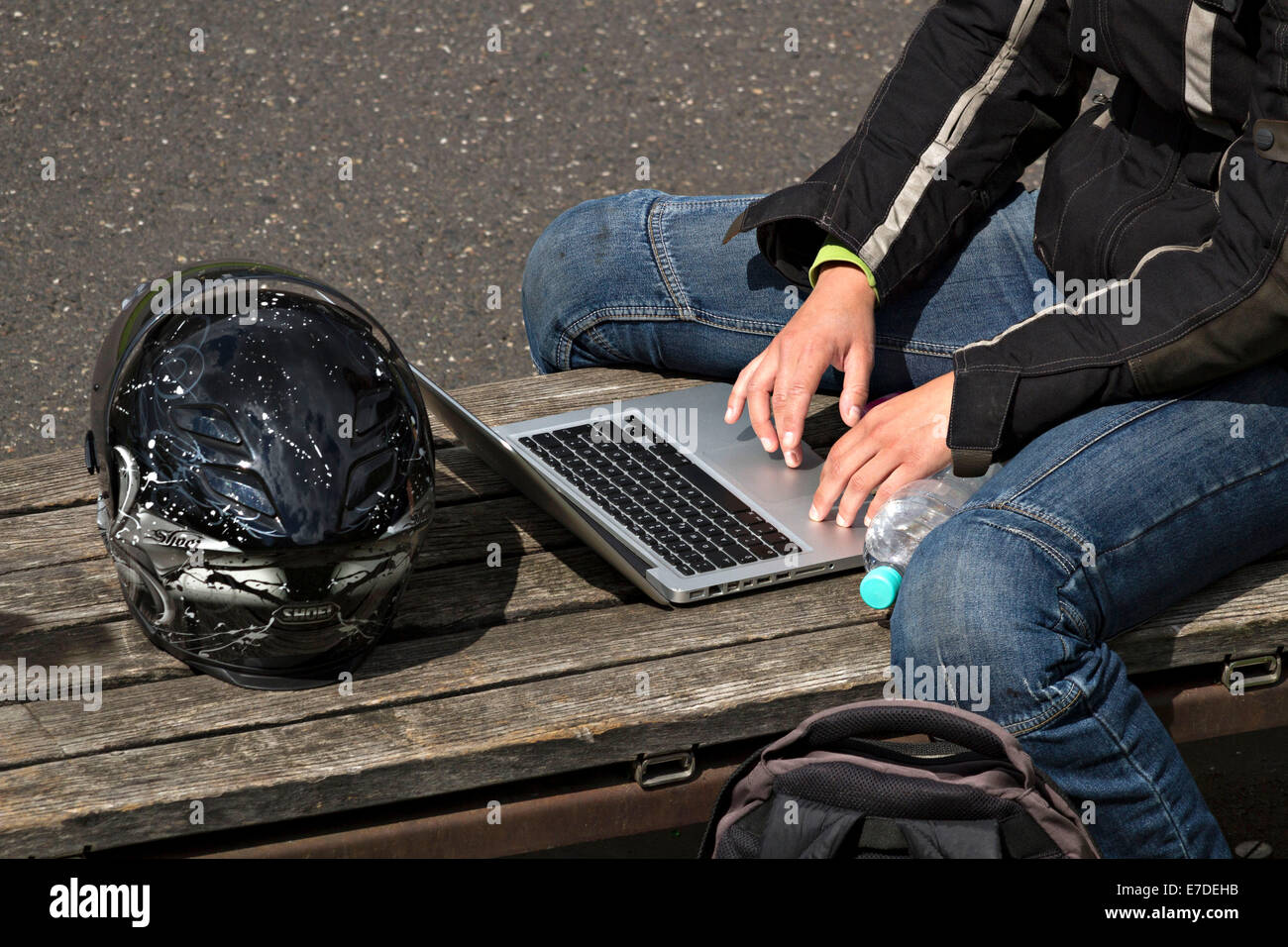 Persona seduta sul sedile posteriore utilizzando un computer portatile Foto Stock