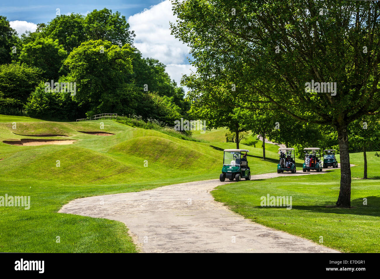 Quattro campi da golf elettrico buggy o carrelli da alcuni bunker su un campo da golf. Foto Stock