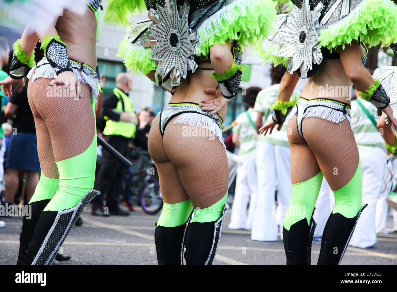 Tre fondi danza il loro modo, vestita di nero, verde e nero piume come parte del carnevale di Hackney. Foto Stock