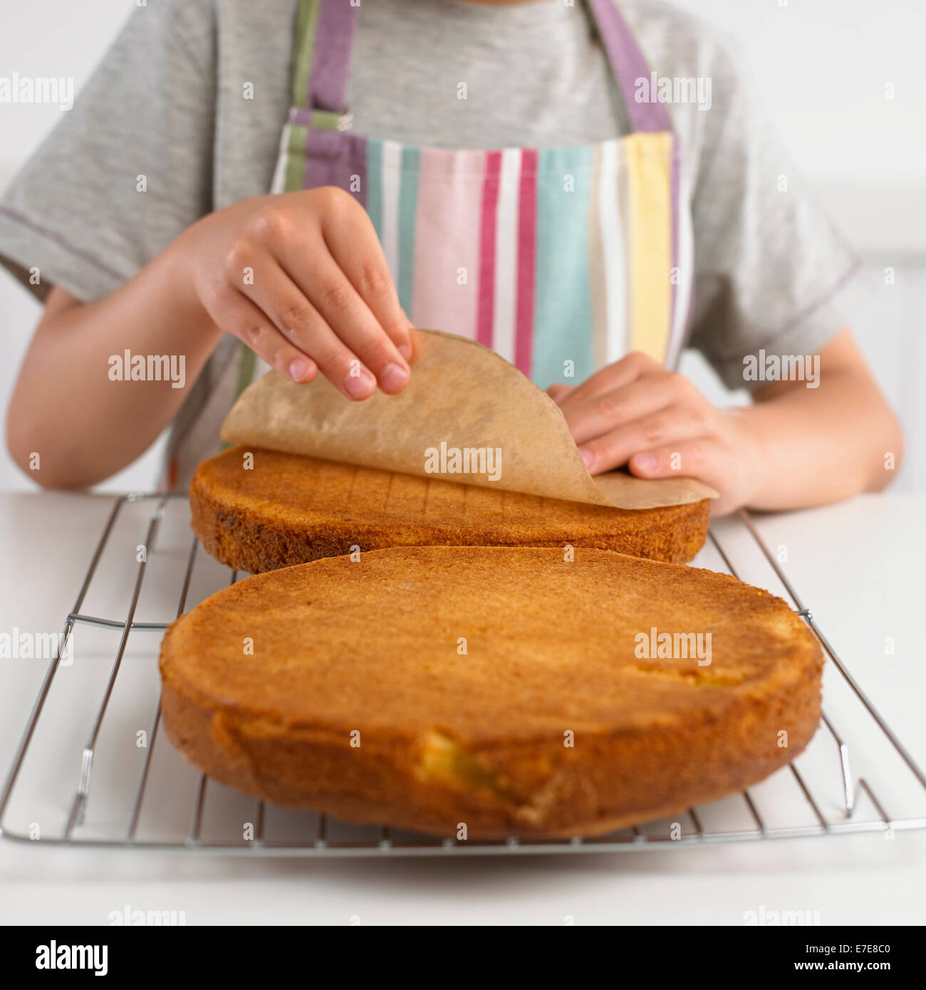 Ragazzo la pelatura di carta oleata da pan di spagna Foto Stock