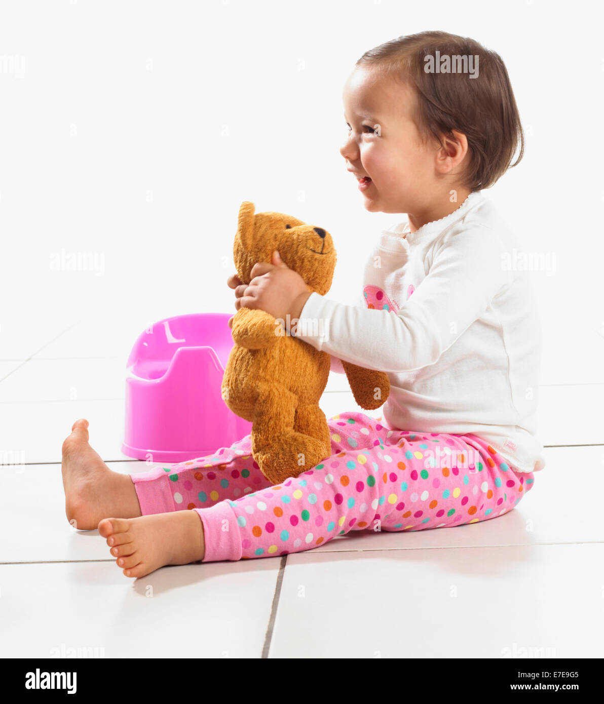 Il Toddler ragazza con Teddy sedeva accanto al vasino, 1,5 anni Foto Stock