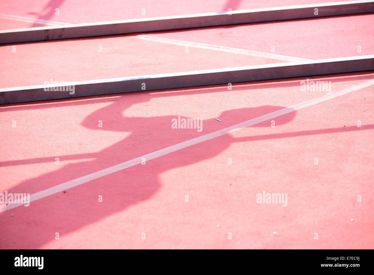 Ombra di un atleta durante l'esercizio sulle barre parallele in una giornata di sole Foto Stock