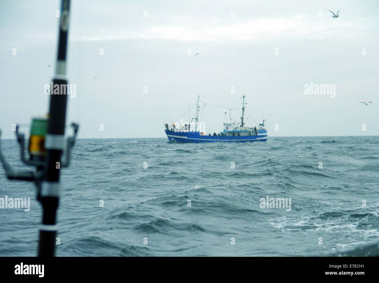 Canna da pesca a spinning-ruota su sfondo del mare Foto Stock