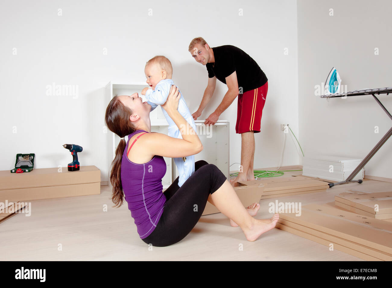 Famiglia giovane con un bambino in movimento in un nuovo appartamento Foto Stock