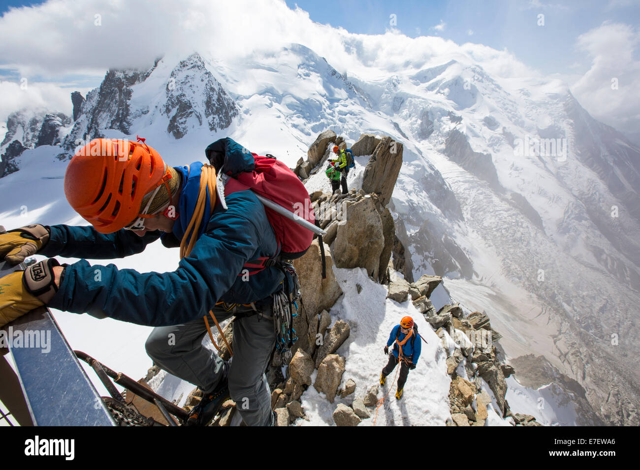 Mont Blanc dall'Aiguille du Midi al di sopra di Chamonix, Francia, con gli alpinisti sul Cosmétiques Arete, salendo la scala per accedere alla stazione della funivia. Foto Stock