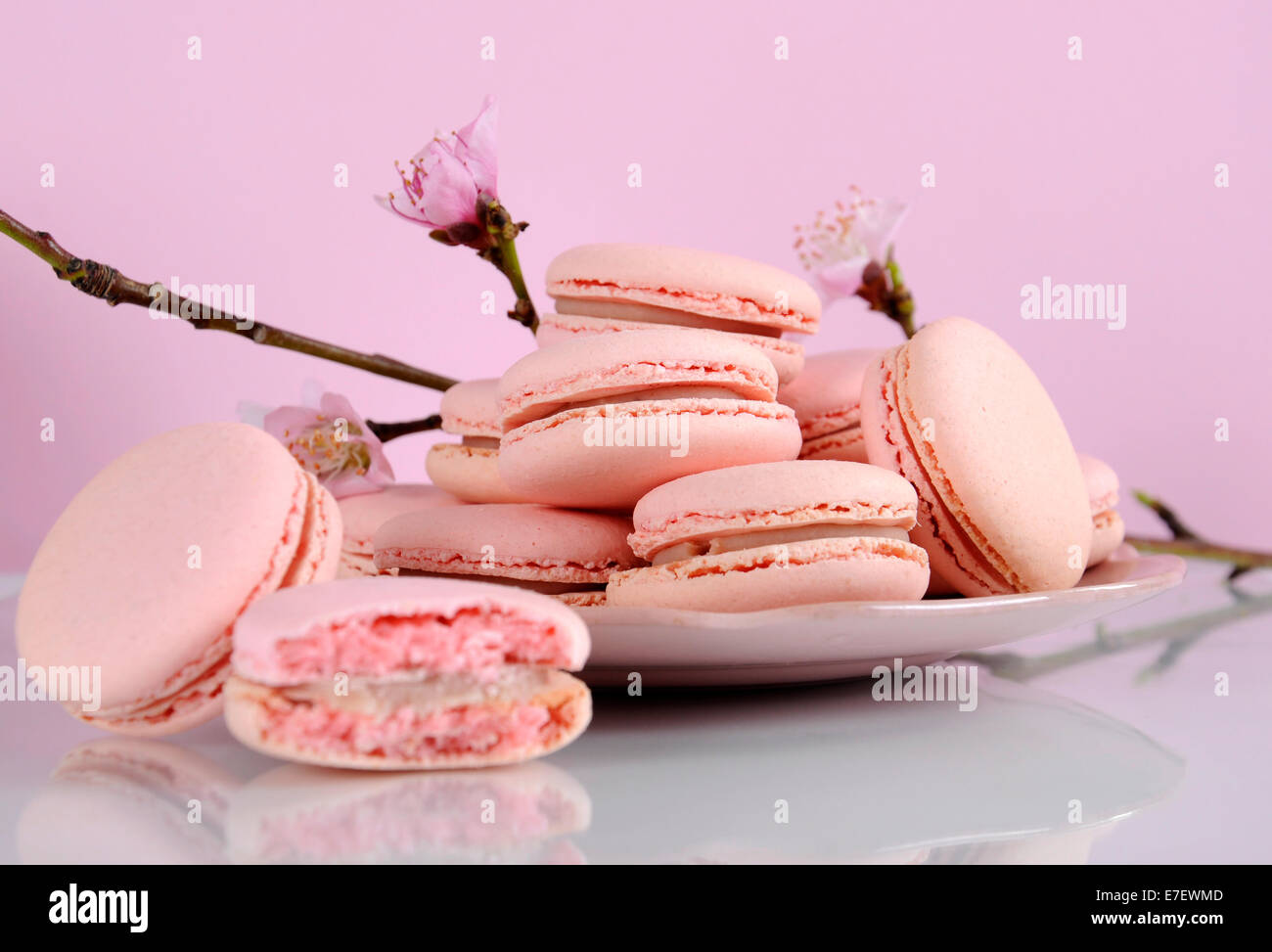 Shabby chic stile vintage piatto di rosa macarons sulla bianca superficie riflettente contro un sfondo rosa. Foto Stock