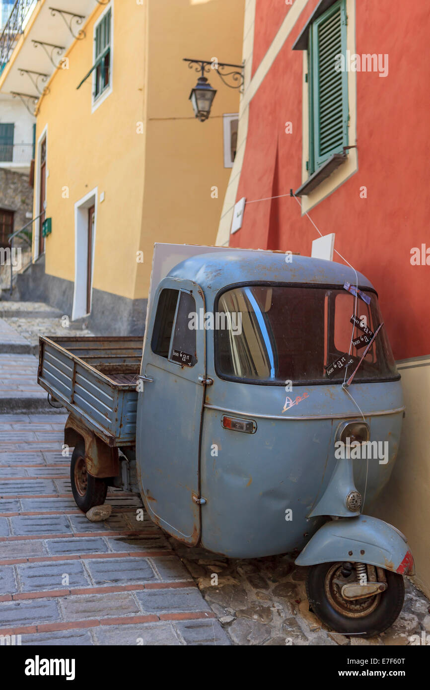 Tipica Italiana a tre ruote di veicolo commerciale leggero parcheggiata in un vicolo, Vallebona, Liguria, Italia Foto Stock
