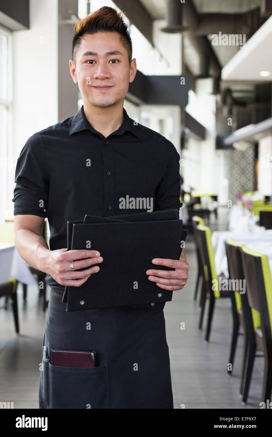 Asian cameriere in piedi in ristorante Foto Stock