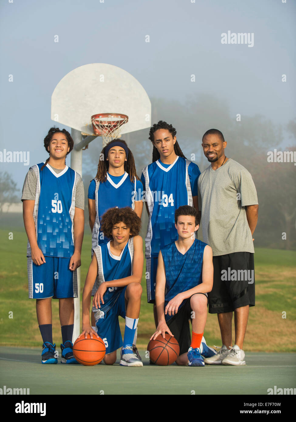 Squadra di basket che posano su corte Foto Stock