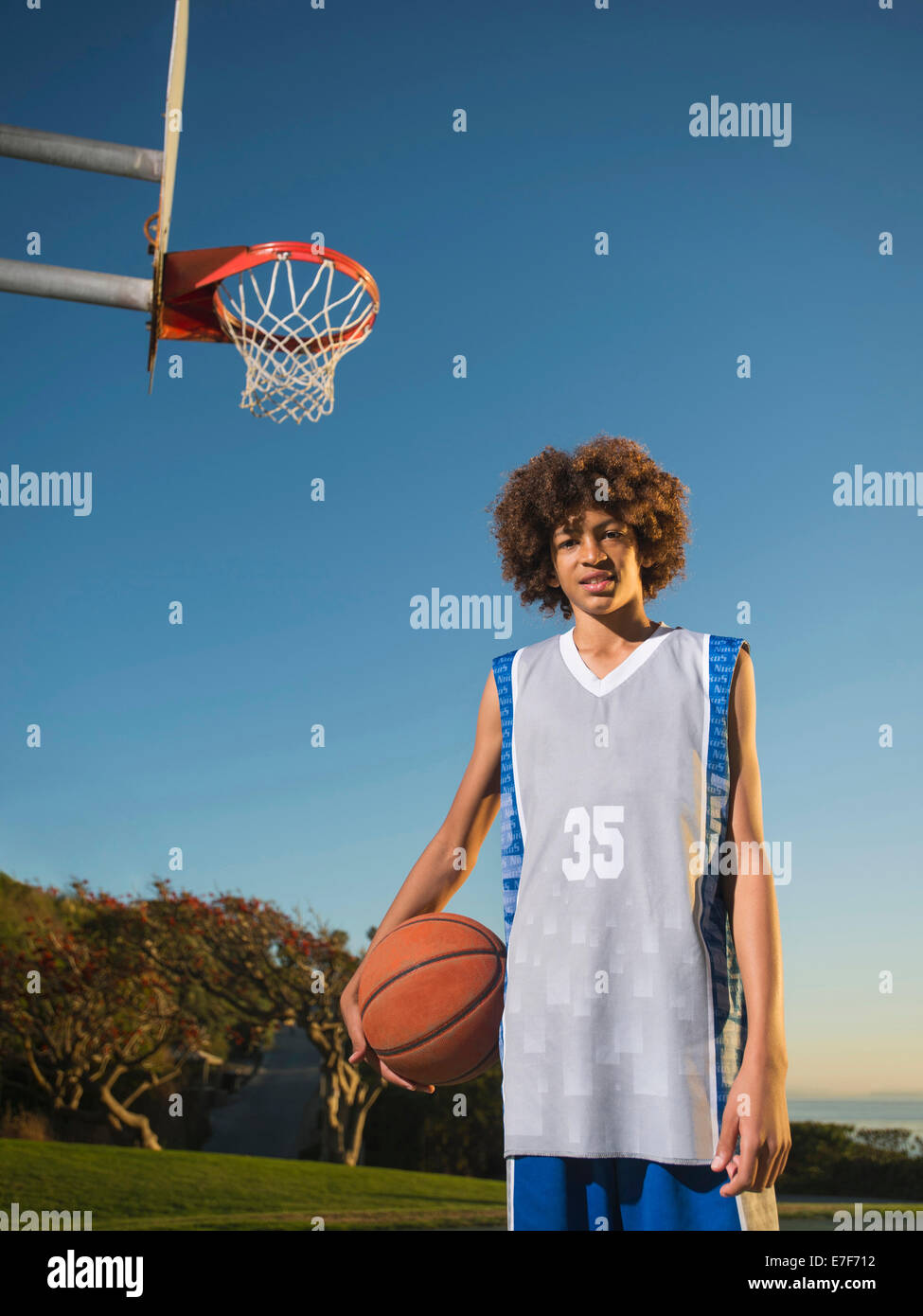 Nero ragazzo adolescente tenendo la pallacanestro su corte Foto Stock
