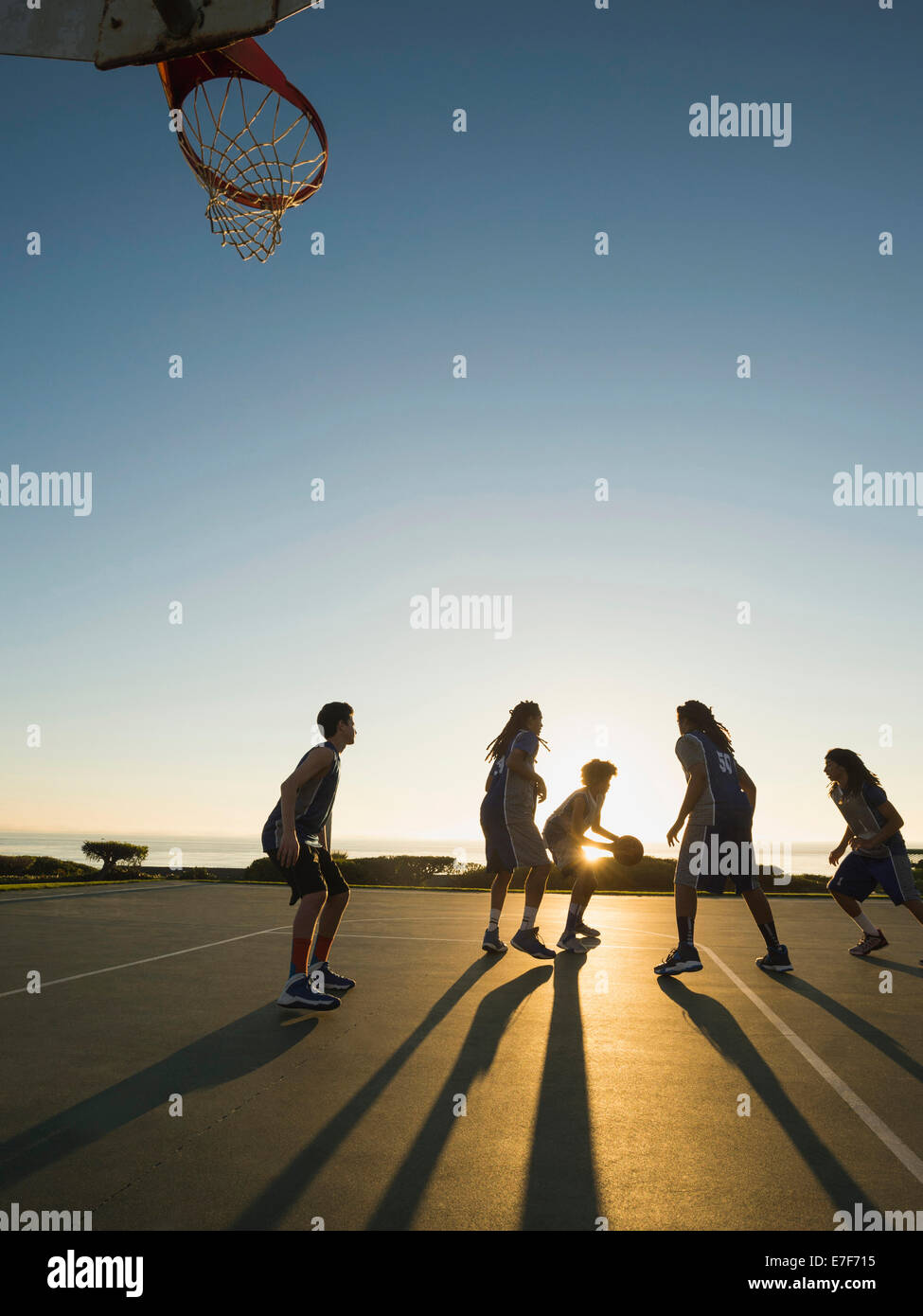 Back lit squadre di pallacanestro giocando su corte Foto Stock