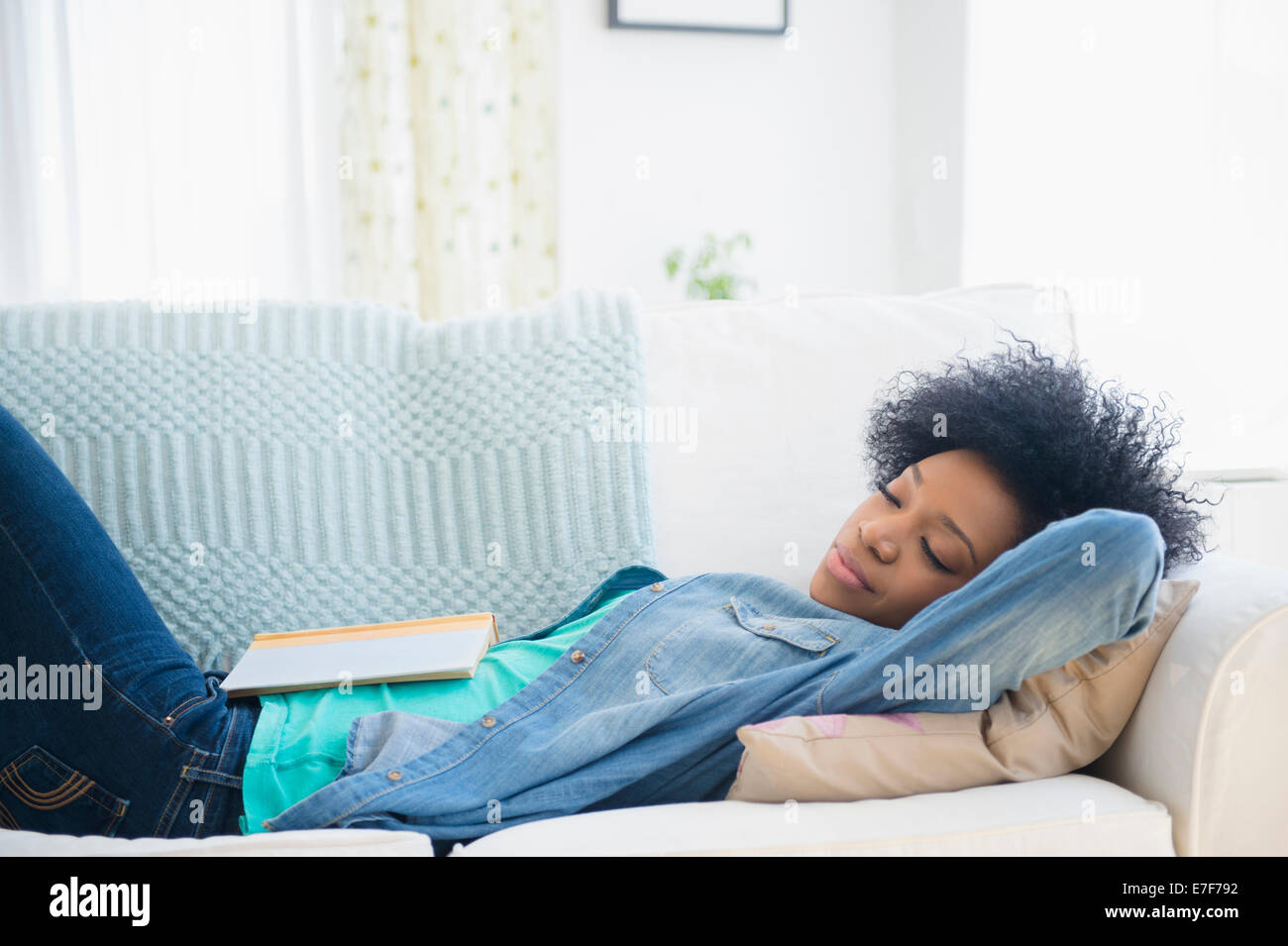African American donna sonnecchiare sul divano Foto Stock