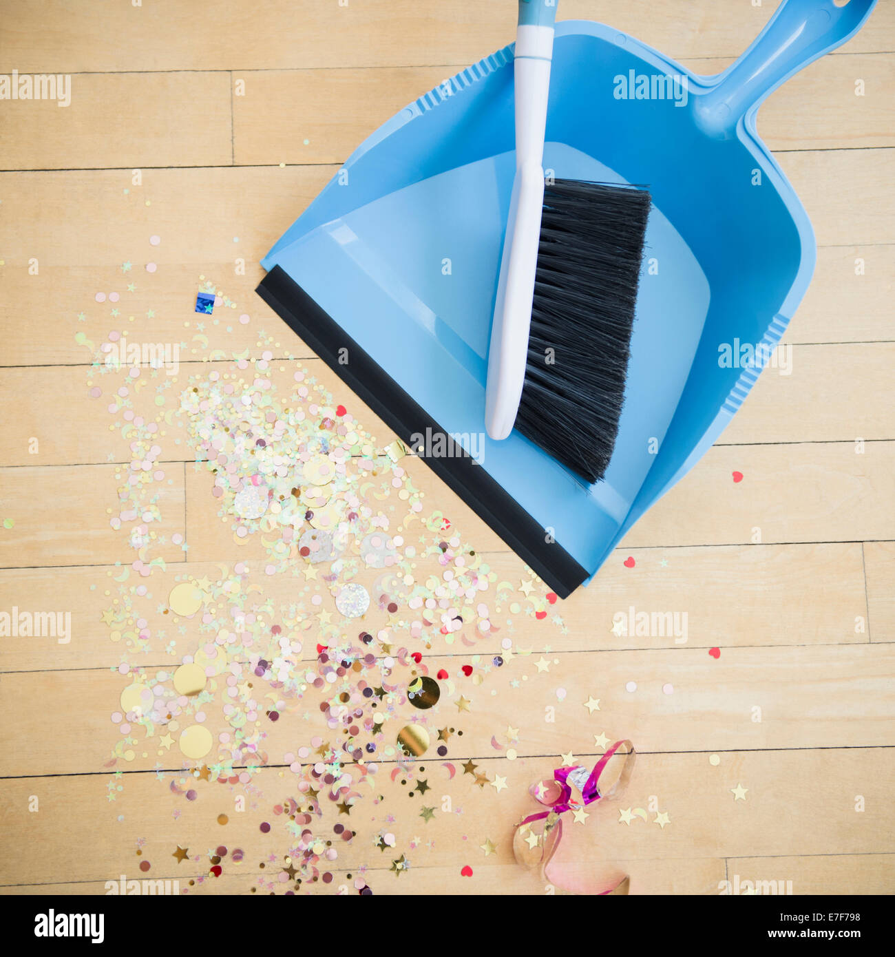 Scopa e paletta con i confetti sul pavimento Foto Stock