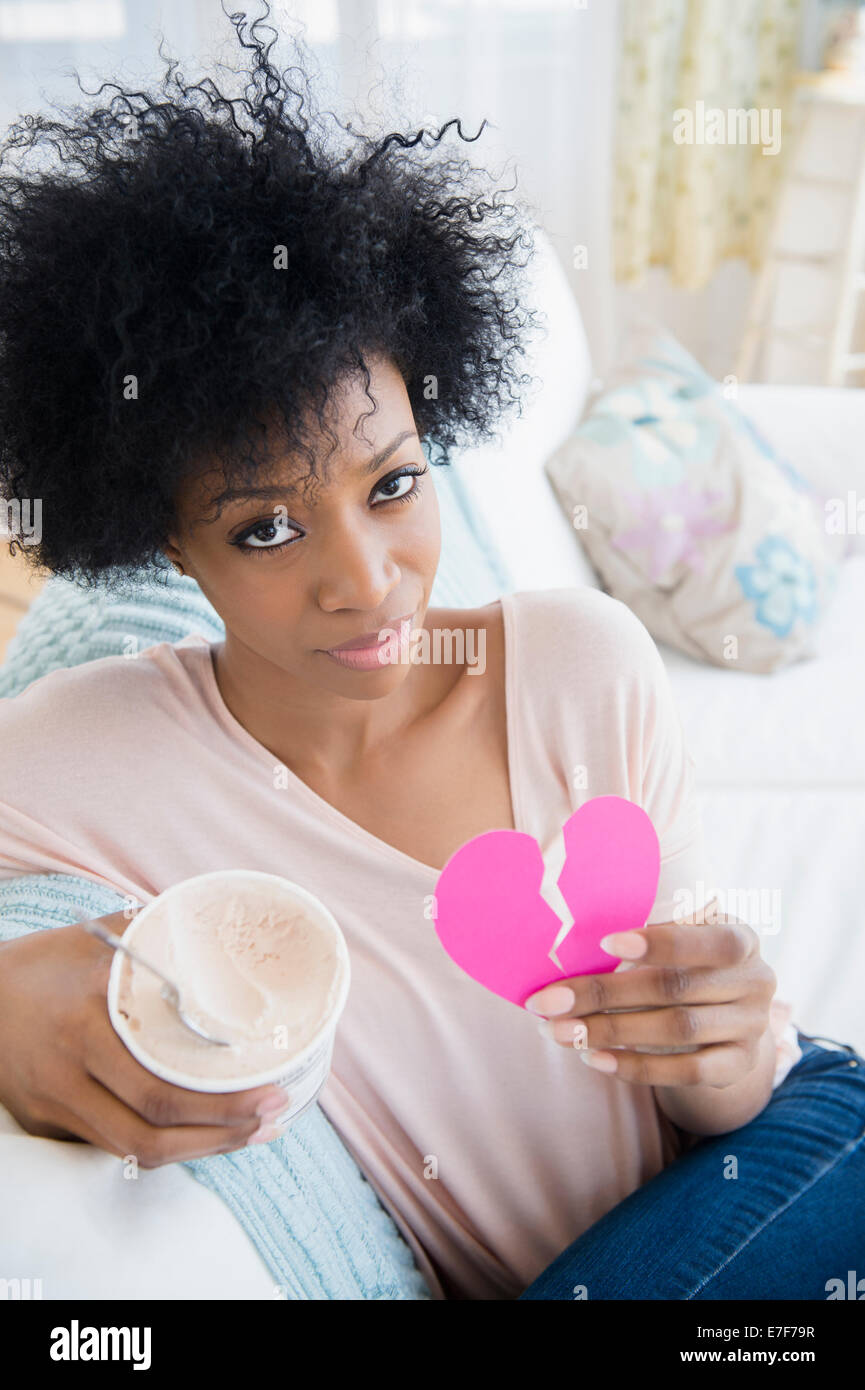 African American donna azienda cuore spezzato e gelato Foto Stock