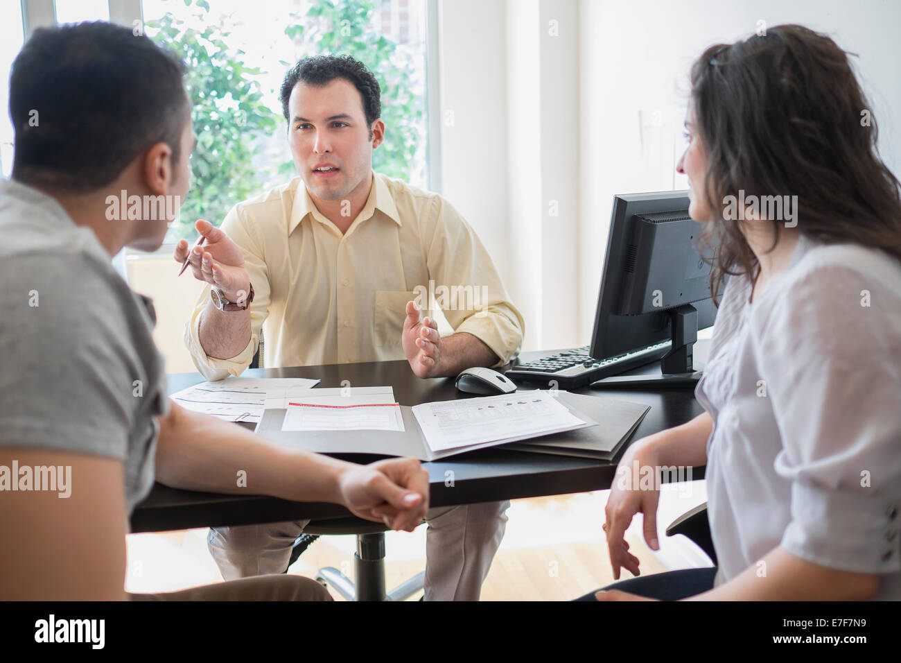 Imprenditore ispanica a parlare con i clienti in ufficio Foto Stock