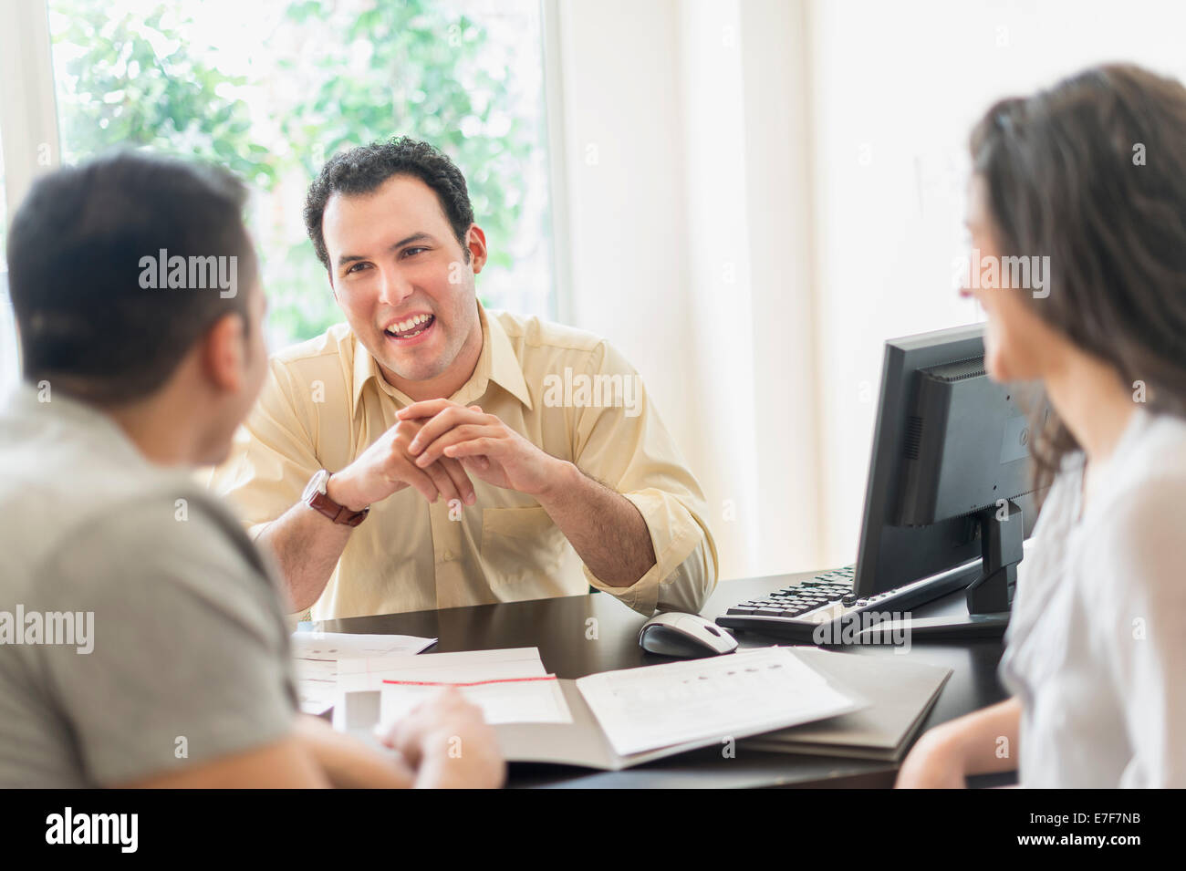 Imprenditore ispanica a parlare con i clienti in ufficio Foto Stock